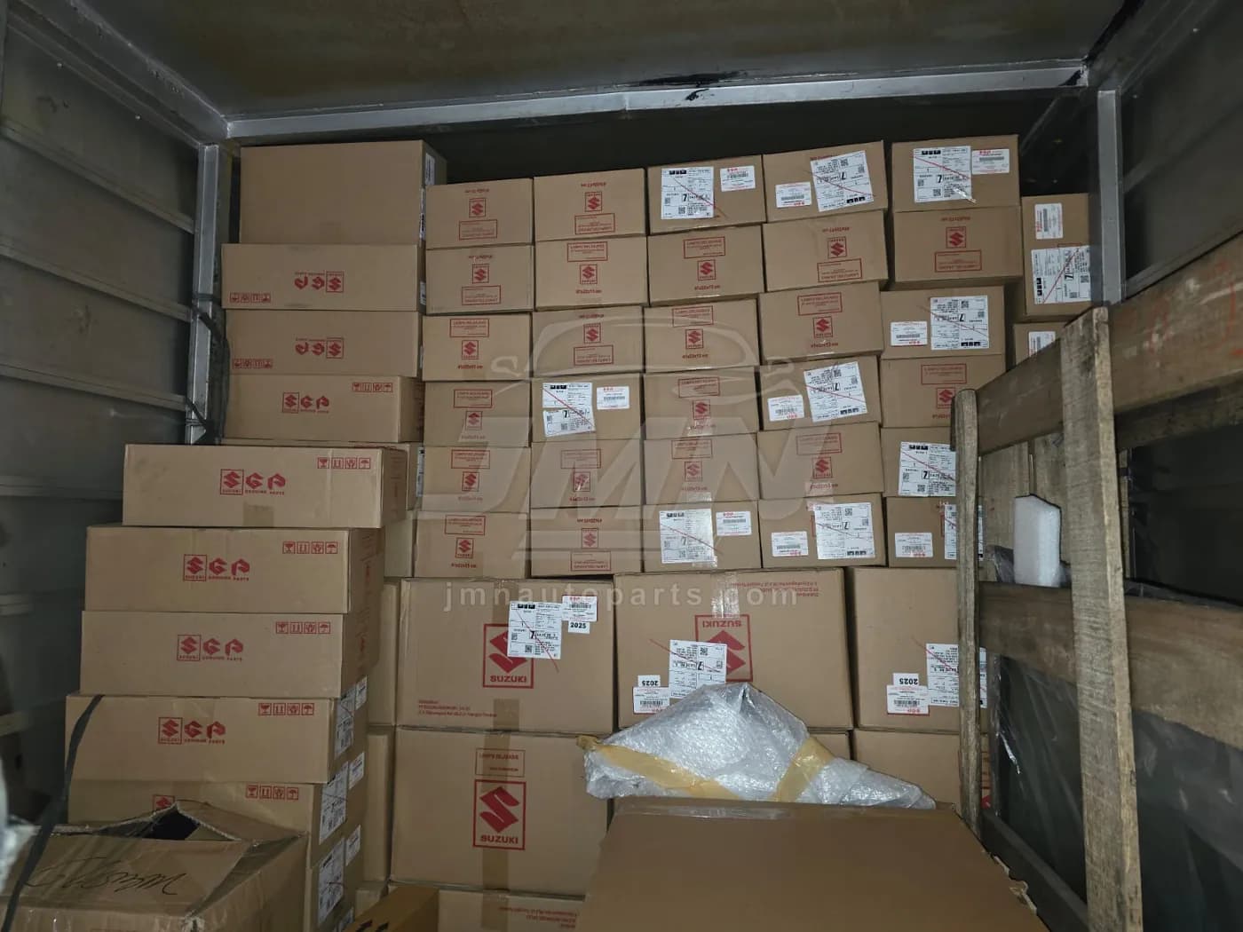Fully loaded delivery truck packed with sealed Suzuki parts cartons before departure