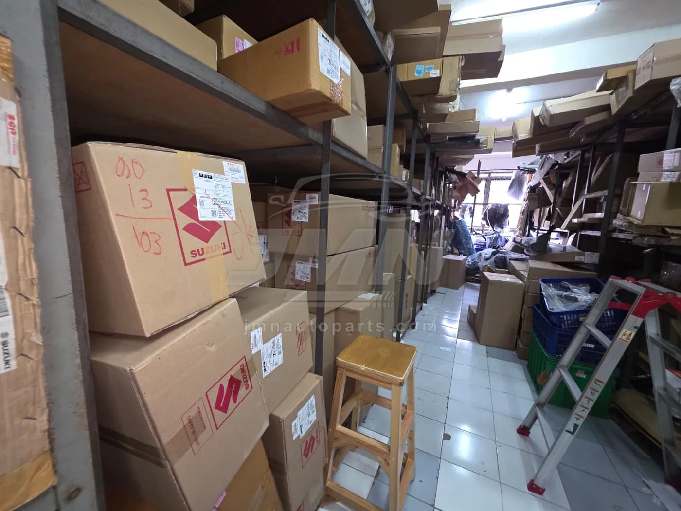 Picking aisle with Suzuki cartons shelved by part number at the JMN warehouse