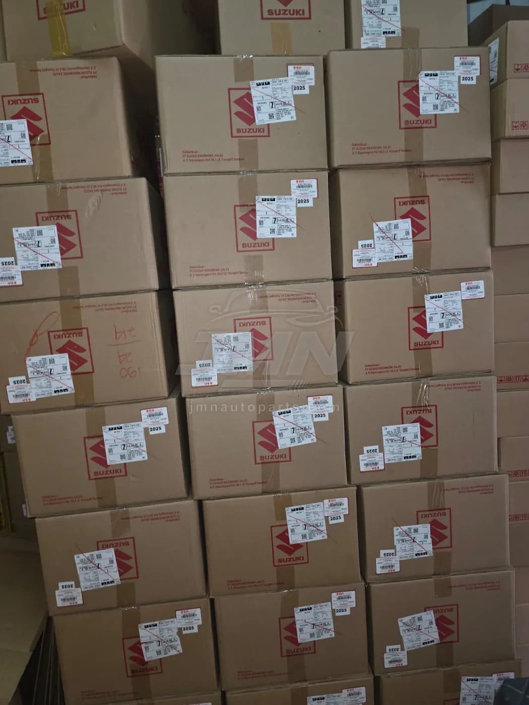 Close-up of Suzuki Genuine Parts cartons showing distributor labels and batch stickers